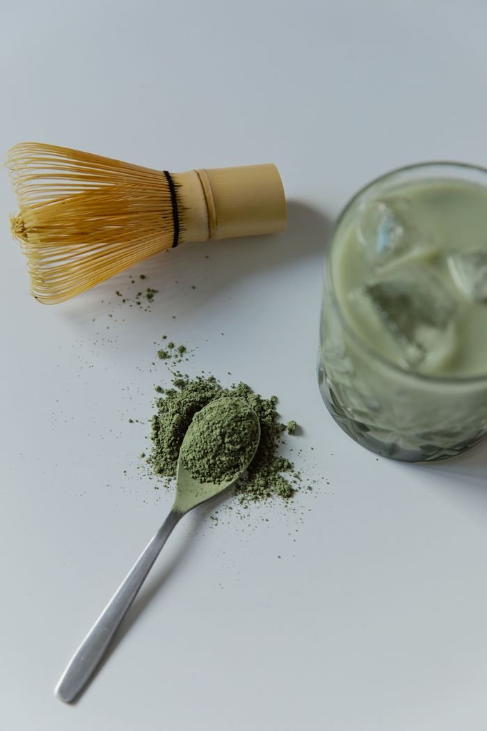 Crafting Captivating Headlines: Your awesome post title goes here Top view of matcha latte with bamboo whisk and green tea powder.